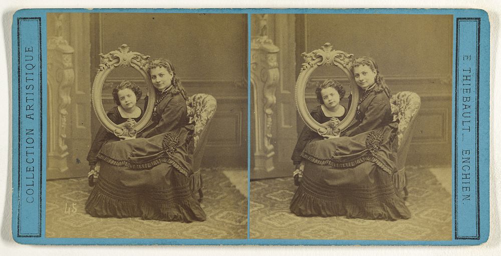 Young woman posed with a child, the child's head is cutely being viewed through an empty picture frame by E Thiébault