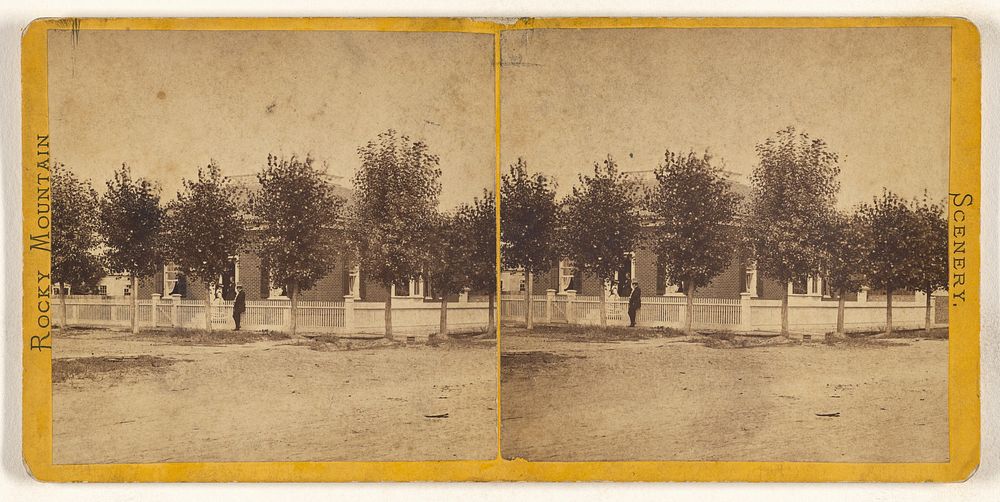 Rocky Mountain Scenery. [Man in hat standing in front of a large tree-lined house, with white picket fence]