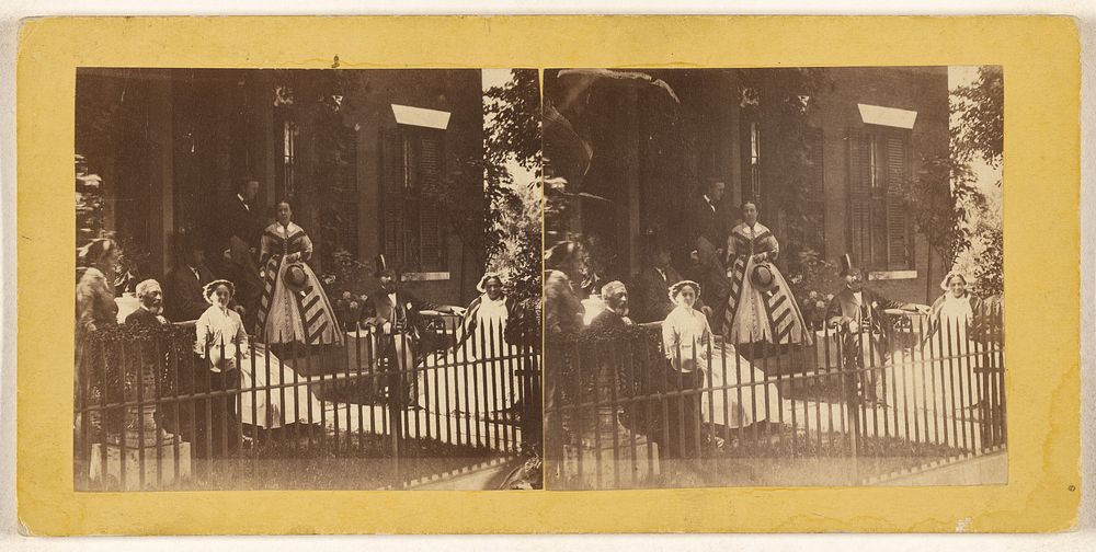 Group of people in the lawn of a fence-enclosed house, probably taken at Brandon, Vermont by Wesley J Cady