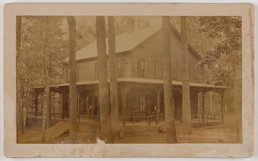 Large house with three people on porch, tall trees in foreground by McGregor