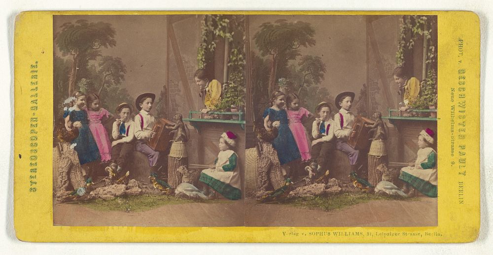 Group of children in native costume posed in a studio, one boy is playing an accordion, a monkey is on a barrel by Pauly…