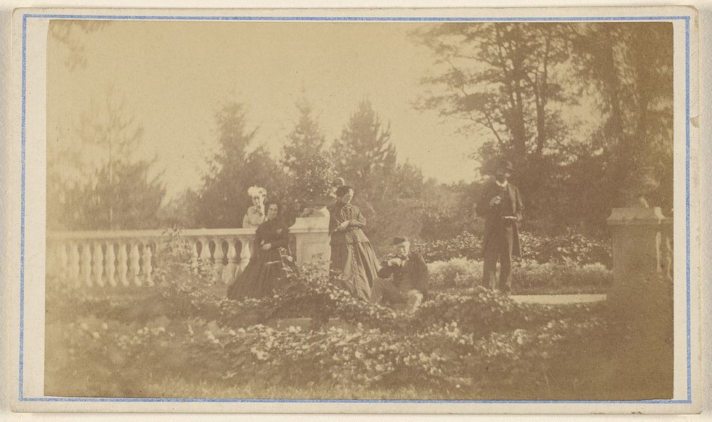 Five unidentified people: three women and one man standing, one man seated, in a garden