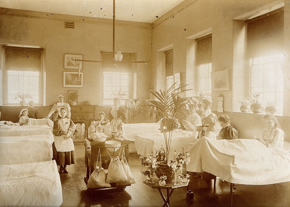 The Royal United Hospital, Bath: nurses and patients on a girls' ward. Photograph, ca. 1870.