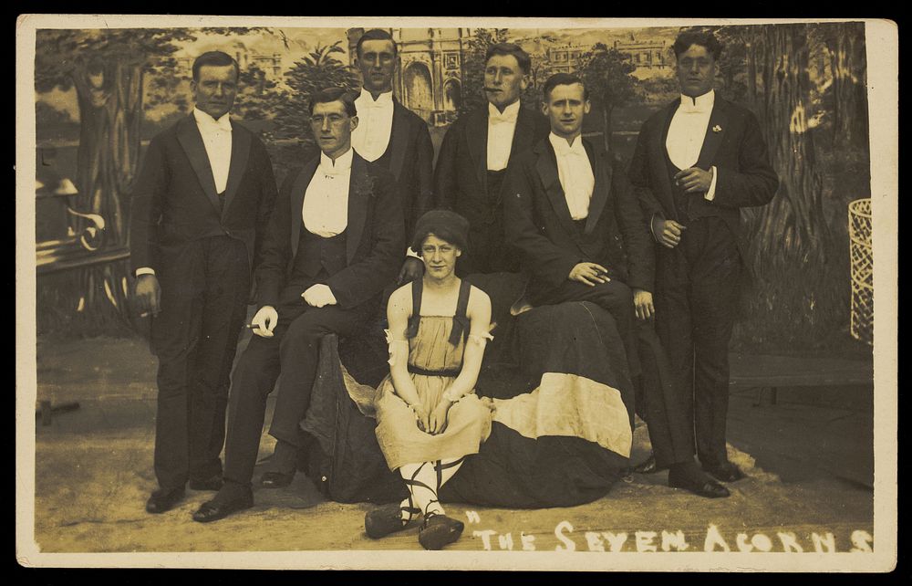 Seven men on stage set of "The seven acorns". Photographic postcard, 1918-1920.