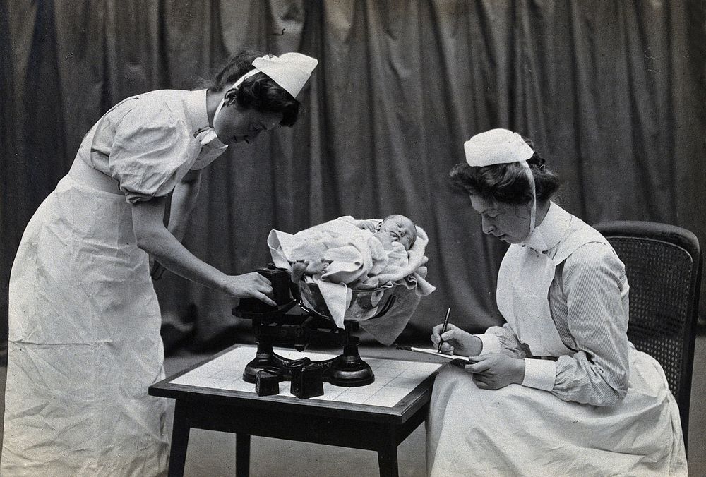 General Lying In Hospital, York Road, Lambeth: nurses weighing a baby. Photograph, 1908.