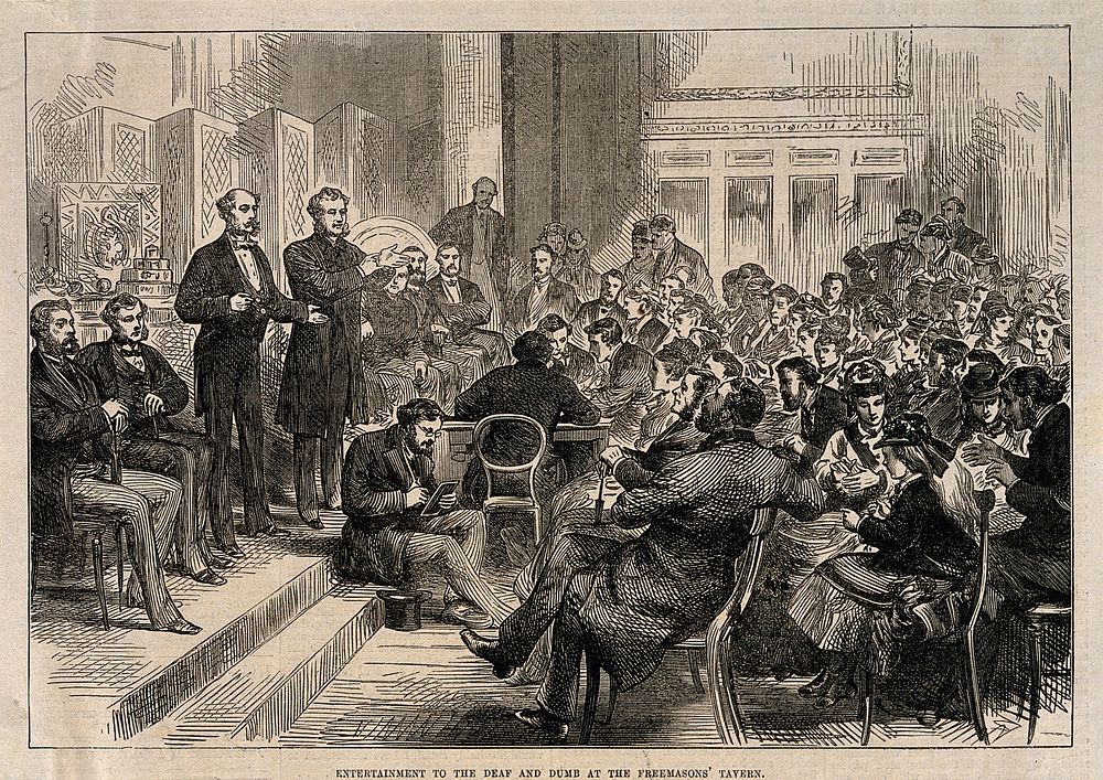 Two men entertain the deaf and dumb in sign language at the Freemason's Tavern. Wood engraving.