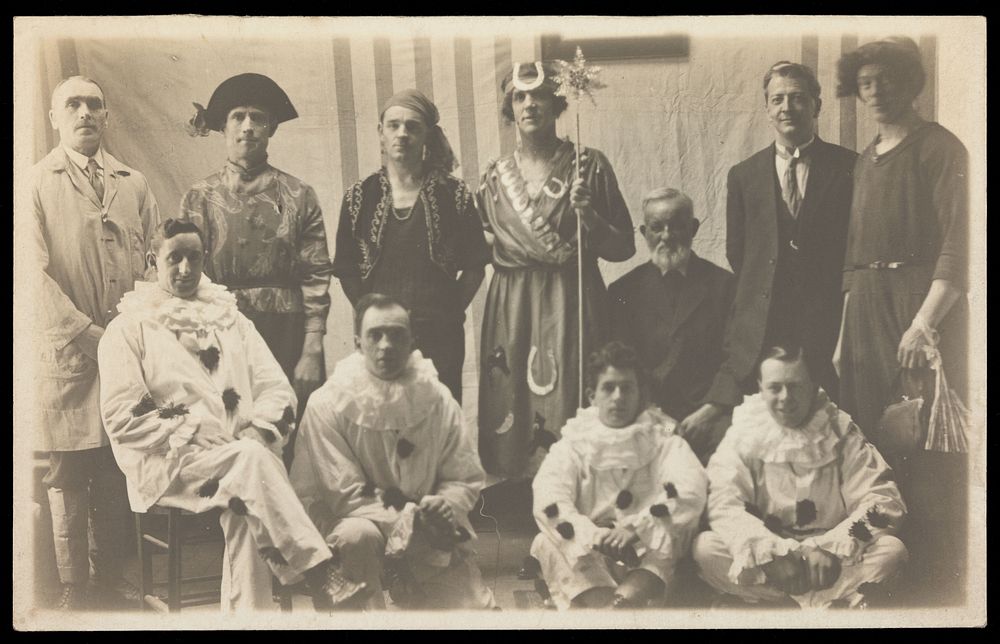 Concert party performers, some in drag, pose for a group portrait. Photographic postcard, 191-.