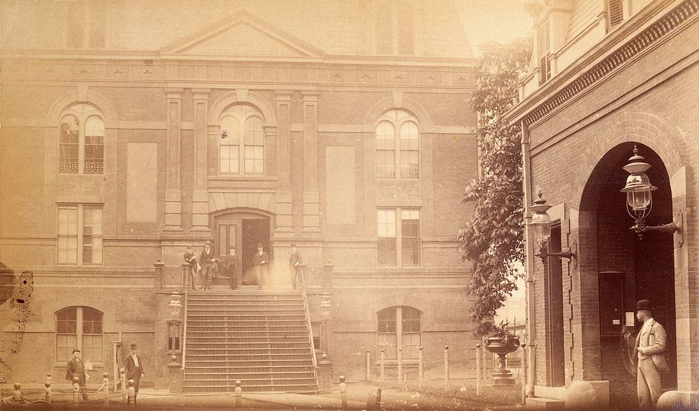 Bellevue Hospital, New York City: a courtyard with (right) back of entrance gateway, (left) a building with pilasters and…