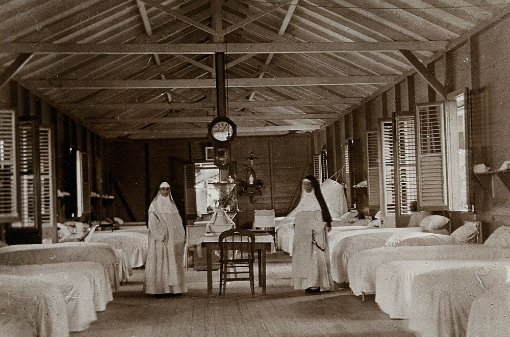 Leper asylum, Port of Spain, Trinidad: two nuns (working as nurses) in a hospital ward with empty beds. Photograph…