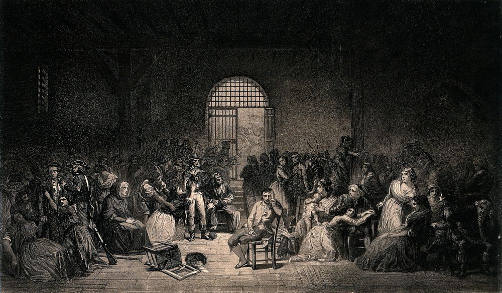 French Revolution: a prisoner sits in the middle of a crowded prison room as a woman nearby pleads with an official.…