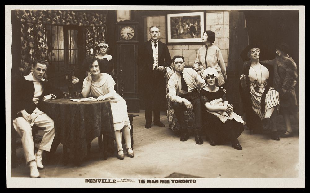 Actors, one in drag, performing "The man From Toronto", pose on set for a group portrait. Photographic postcard, 192-.
