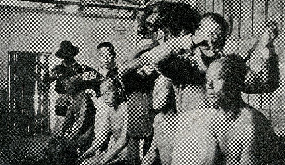 Chinese men having their hair de-loused. Reproduction of a photograph, ca. 1900 .