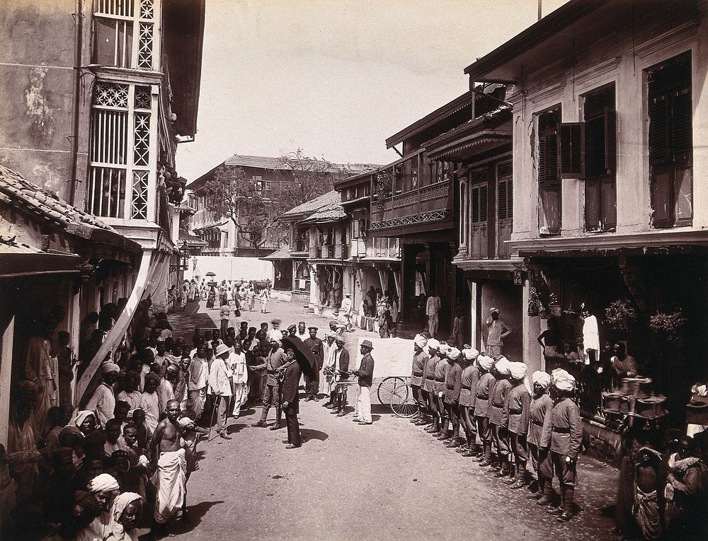 A group of officials making a visit to a house in Bombay, suspected of holding people with plague. Photograph, 1896.