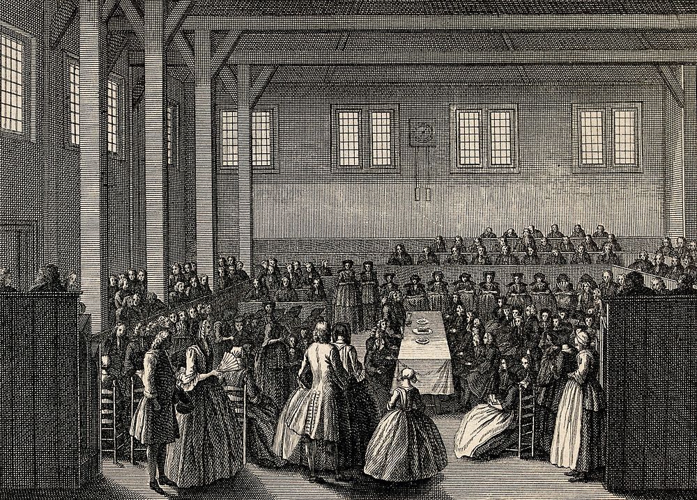 In a room crowded with people a couple walk towards a table laid with three plates. Engraving.