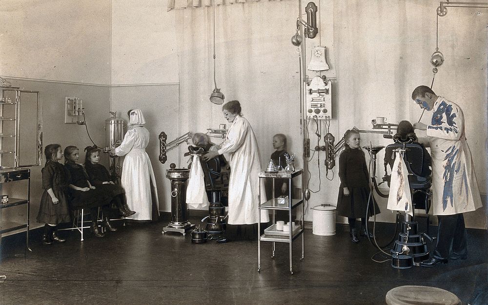 A school-children's dental clinic in Berlin: some children being treated and others waiting, all are girls. Photograph.