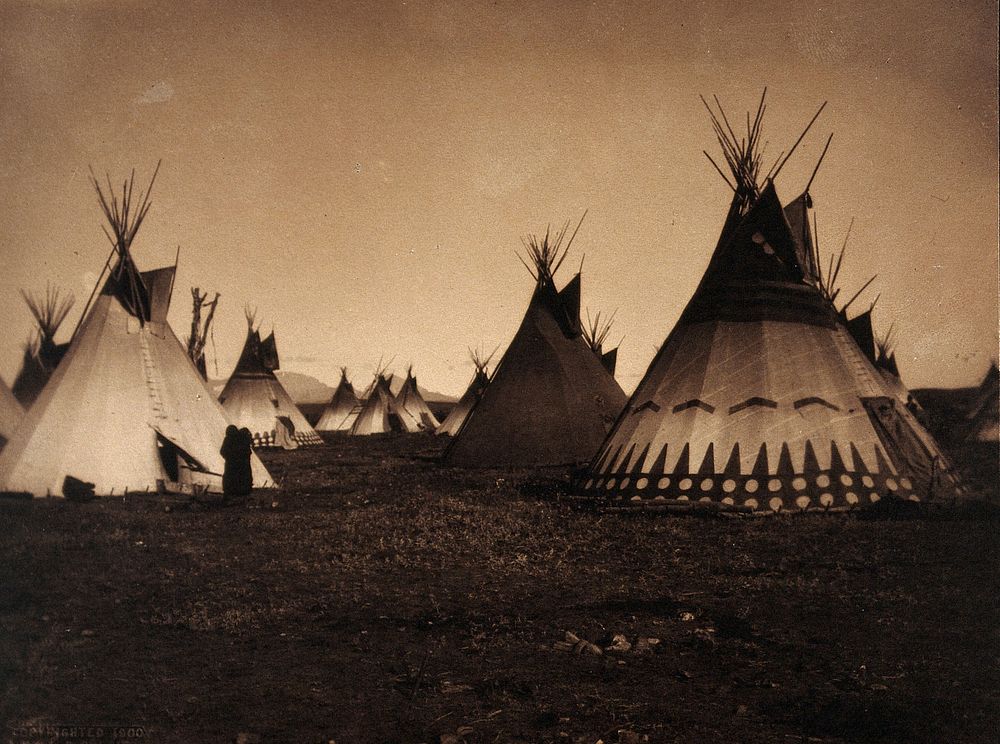 A Piegan encampment, North America: tipis, including a decorated medicine tipi. Photograph by Edward S. Curtis, 1900.