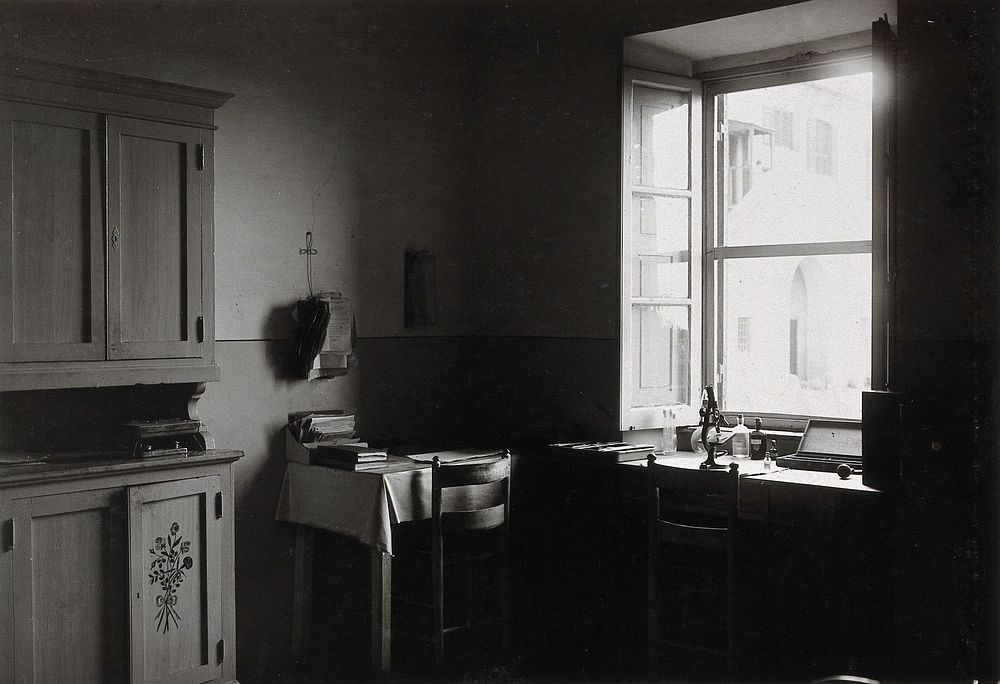 The anti-malaria school, Nettuno, Italy: dispensary interior showing a microscope, bottles and paperwork on tables.…