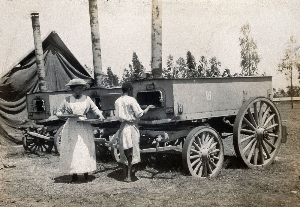 Mobile ovens for food provision to the King's African Rifles (KAR), Nairobi, Kenya; a Western woman and an African man…