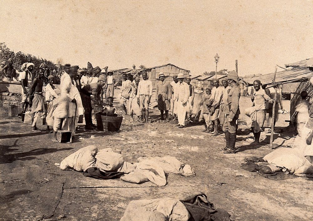 Officers washing members of the Nusserpuri camp, set up as part of the Karachi Plague Committee, India. Photograph, 1897.