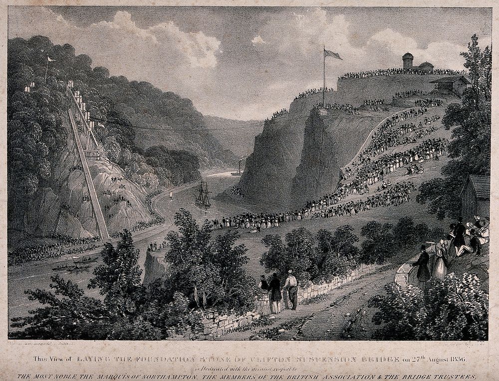 Crowds of people are standing on hillsides looking down on to a river in the valley over which the Clifton suspension bridge…