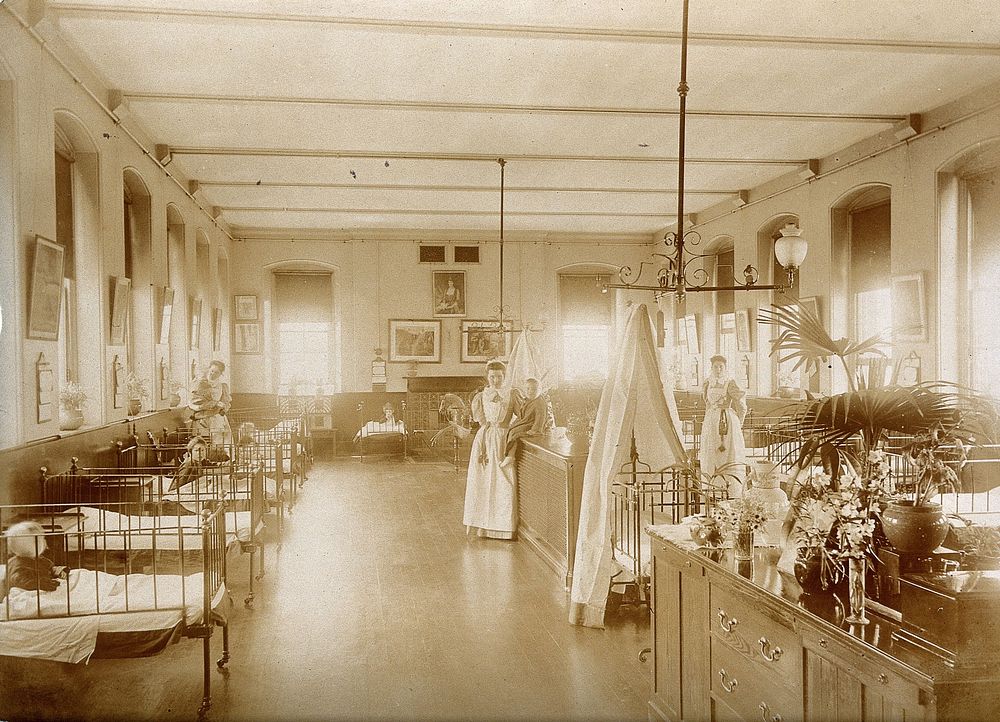 The Royal United Hospital, Bath: nurses with patients in cots on a children's ward. Photograph, ca. 1870.