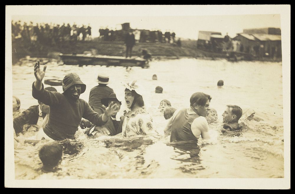 A group of men, one in drag, swimming and playing in a river.