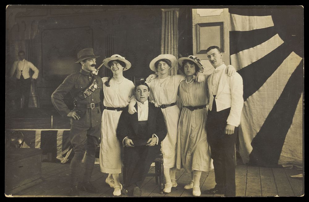 Servicemen performing a play, in front of the stage. Photographic postcard. 191-.