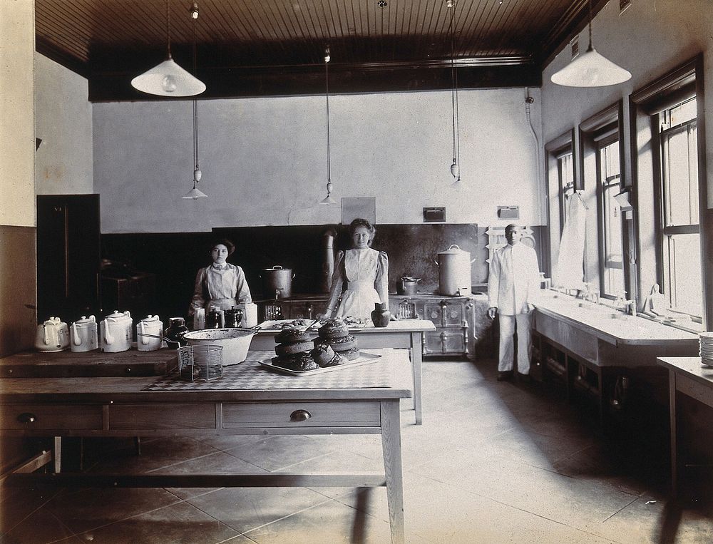 Johannesburg Hospital, South Africa: kitchen area with staff, tea pots and cake. Photograph, c. 1905.