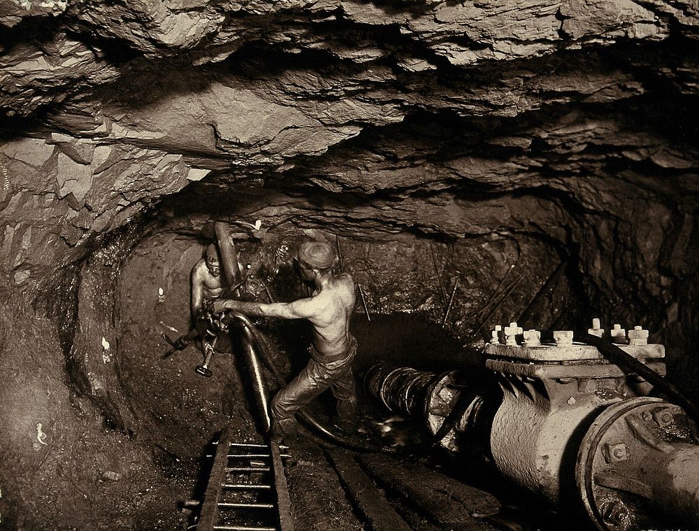 Tincroft tin mine, near Camborne, Cornwall: two miners at work in a mine shaft. Photograph by J. C. Burrow, 1890/1910.
