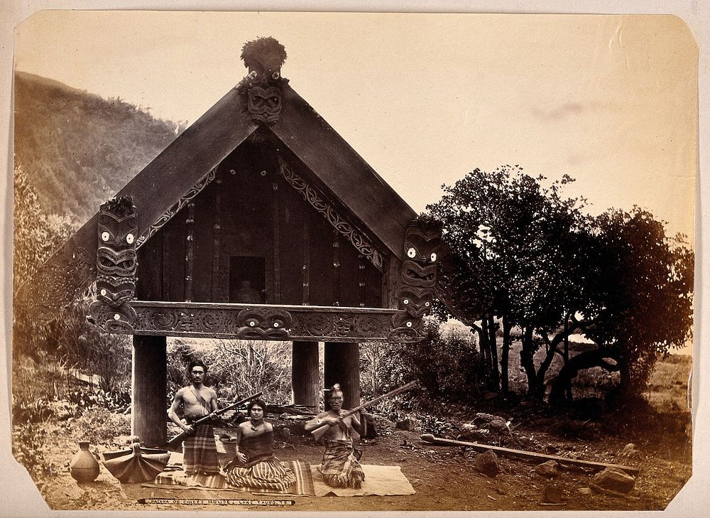 Lake Taupo, New Zealand: Maori men and woman seated before a traditional house. Albumen print.