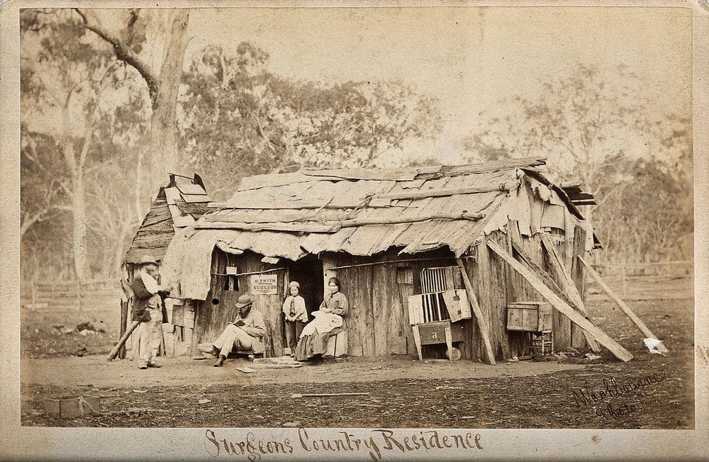 Doctor Smith, an Australian surgeon, sitting outside a shack, reading a book. Photograph by T.J. Washbourne, ca. 1870/1888.