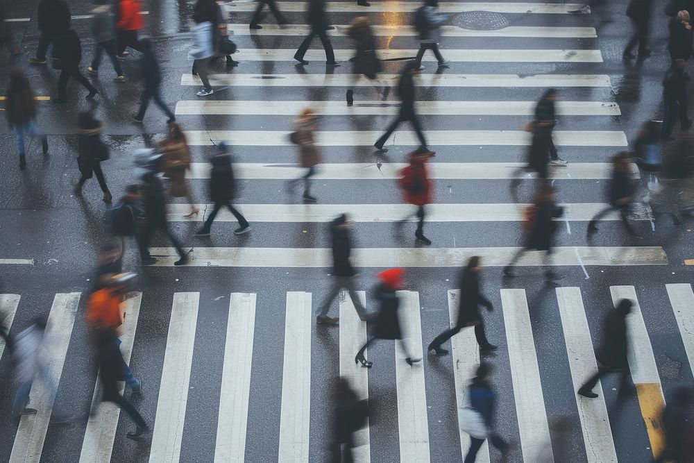 A motion blurry photo of people crossing a street walking adult road.