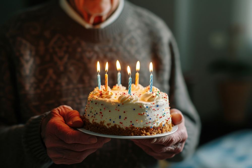 Elderly man holding birthday cake dessert party food.