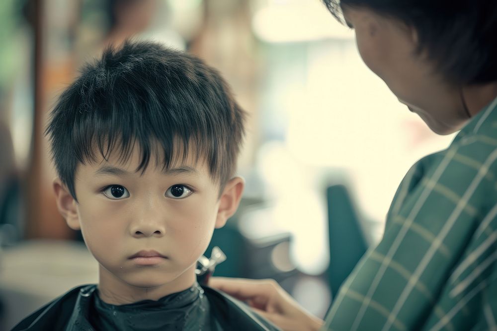 Asian boy getting a haircut in barber child togetherness hairdresser.