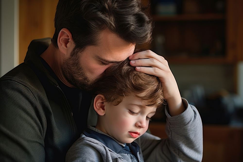 Photo of dad take care to his sick son at home worried crying baby.