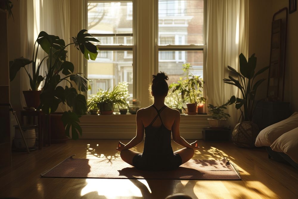 A woman poses for yoga in an apartment living room sports adult plant.