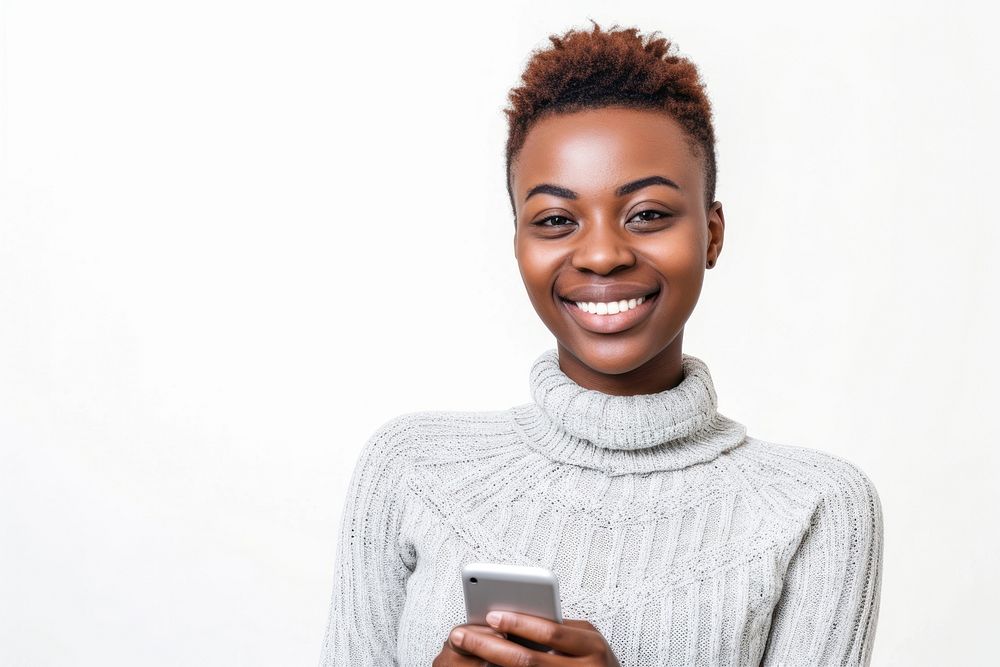African woman with short haircut holding cellphone sweater smiling smile.