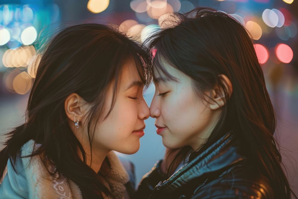 Asian lesbian couple kiss portrait affectionate togetherness.
