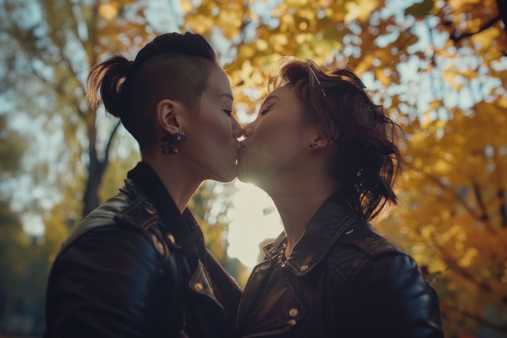 Non-binary couple kiss portrait outdoors kissing.