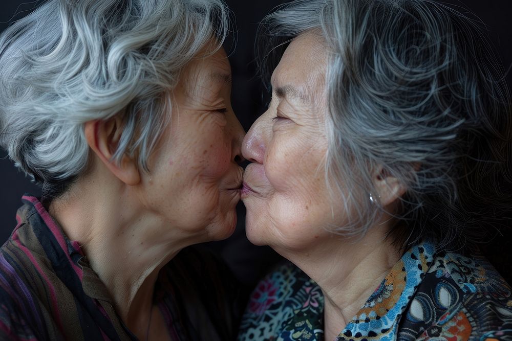 Older asian lesbian couple kiss portrait kissing adult.