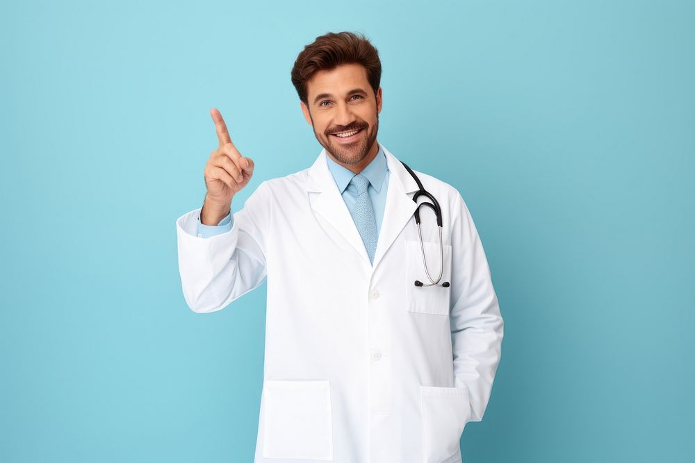 A smiling male doctor is pointing at floating in air mini white board adult stethoscope accessories.