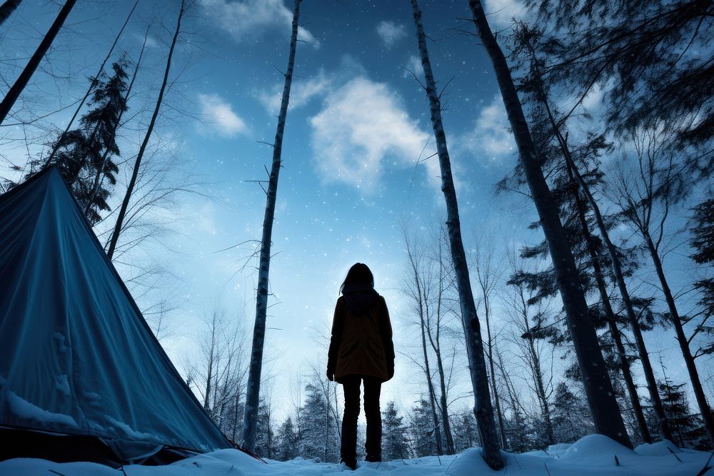 Woman standing in front of tent forest sky outdoors.