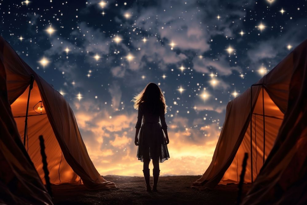 Woman standing in front of tent night astronomy outdoors.