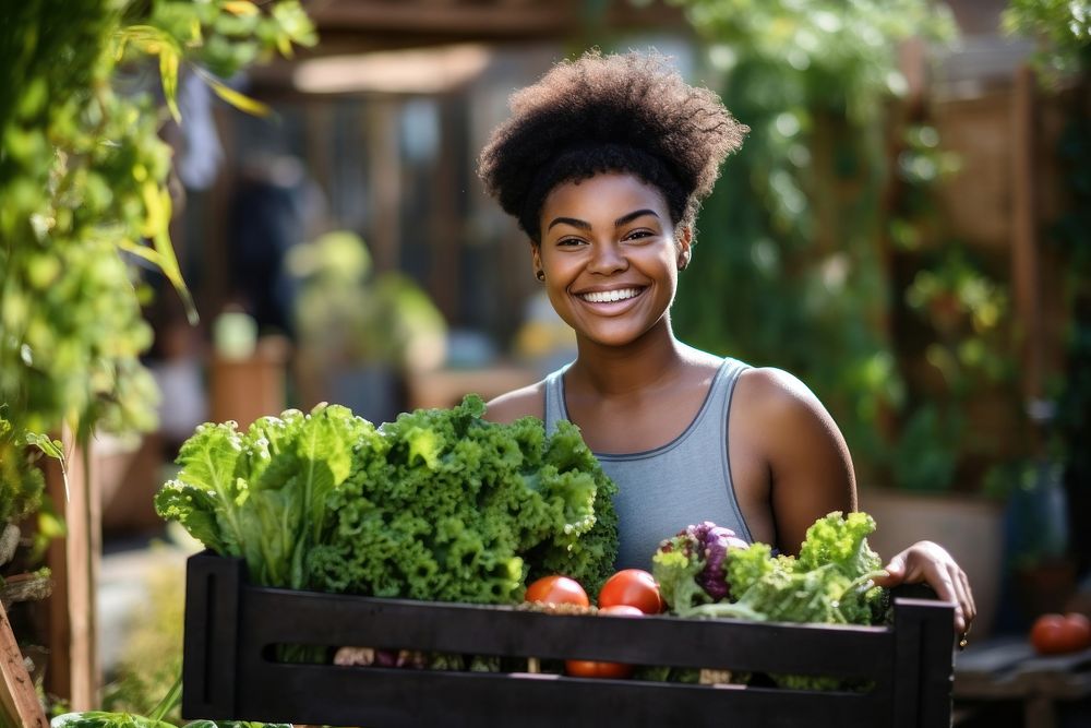 African-American women carrying a vegetable box smile adult outdoors.