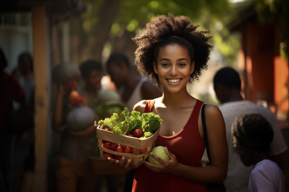 African-American women carrying a vegetable box smile adult plant.