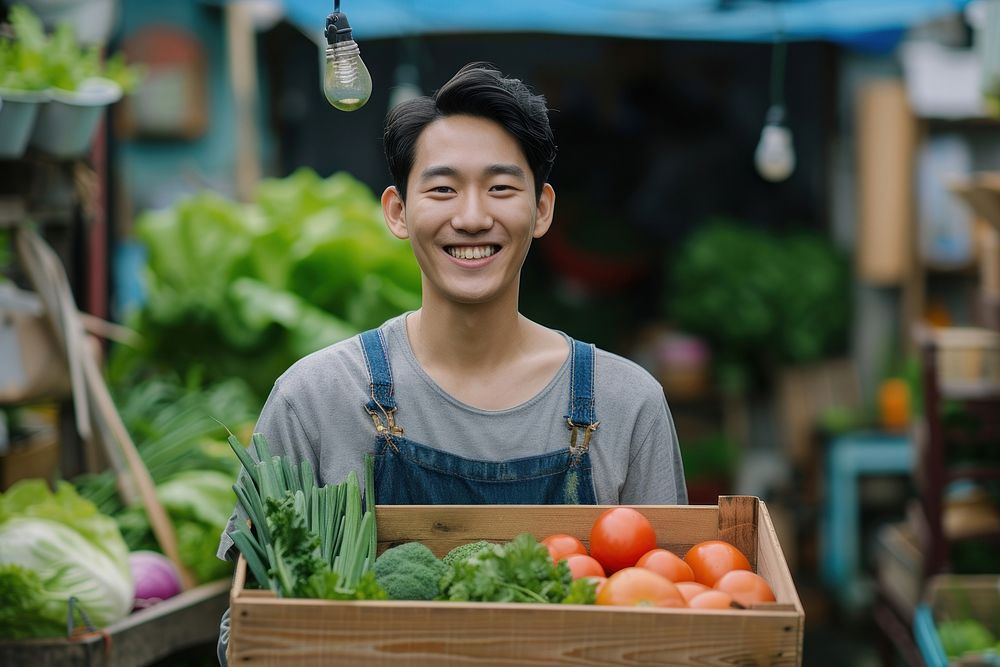 Young korean man carrying a vegetable box smile adult plant.