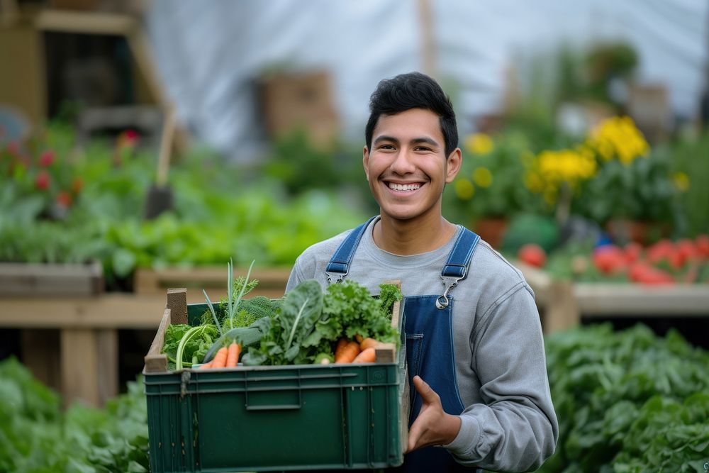 Young Latino man carrying a vegetable box garden smile gardening.