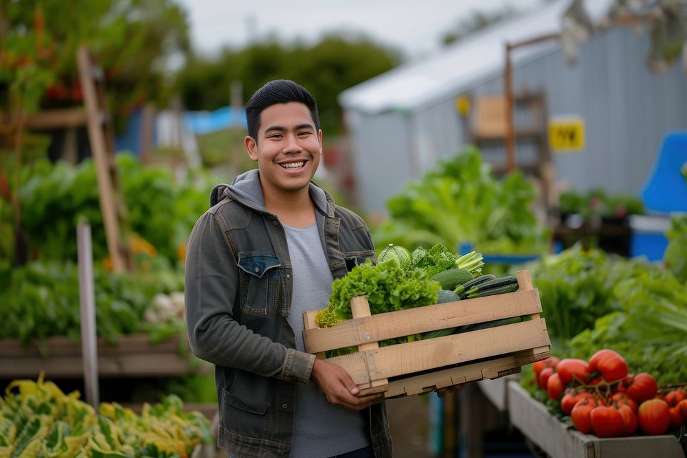 Young Latino man carrying a vegetable box adult market smile.