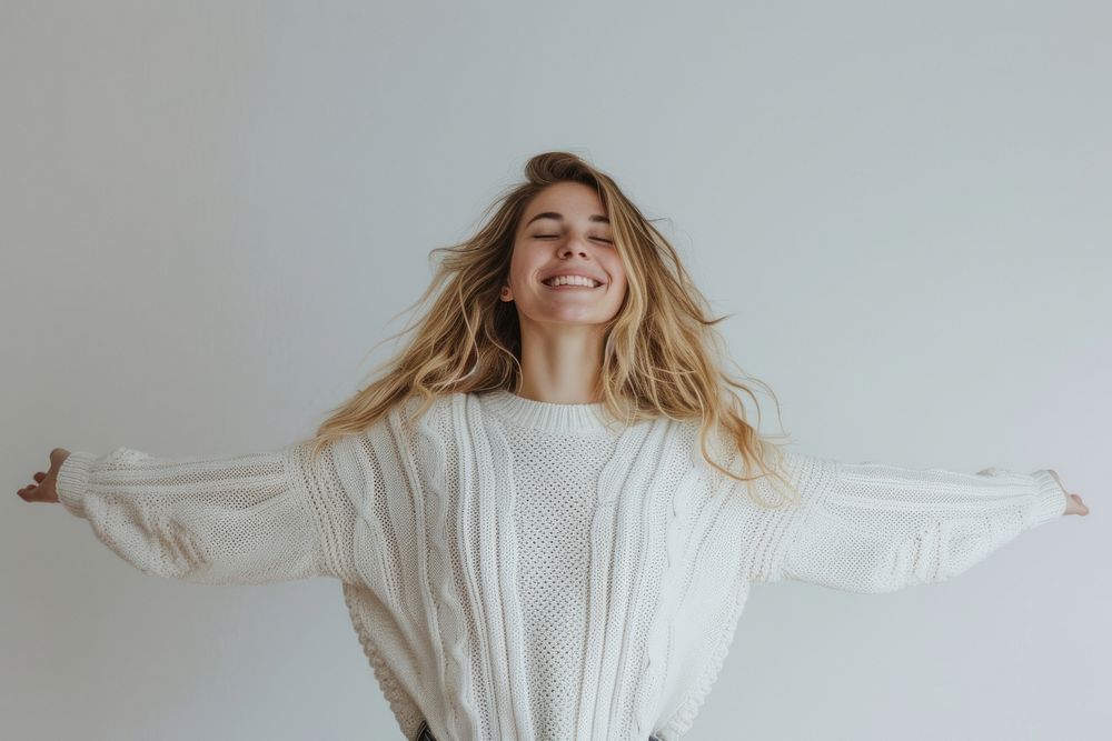 Smiling woman in weater arms outstretched portrait sweater smile.