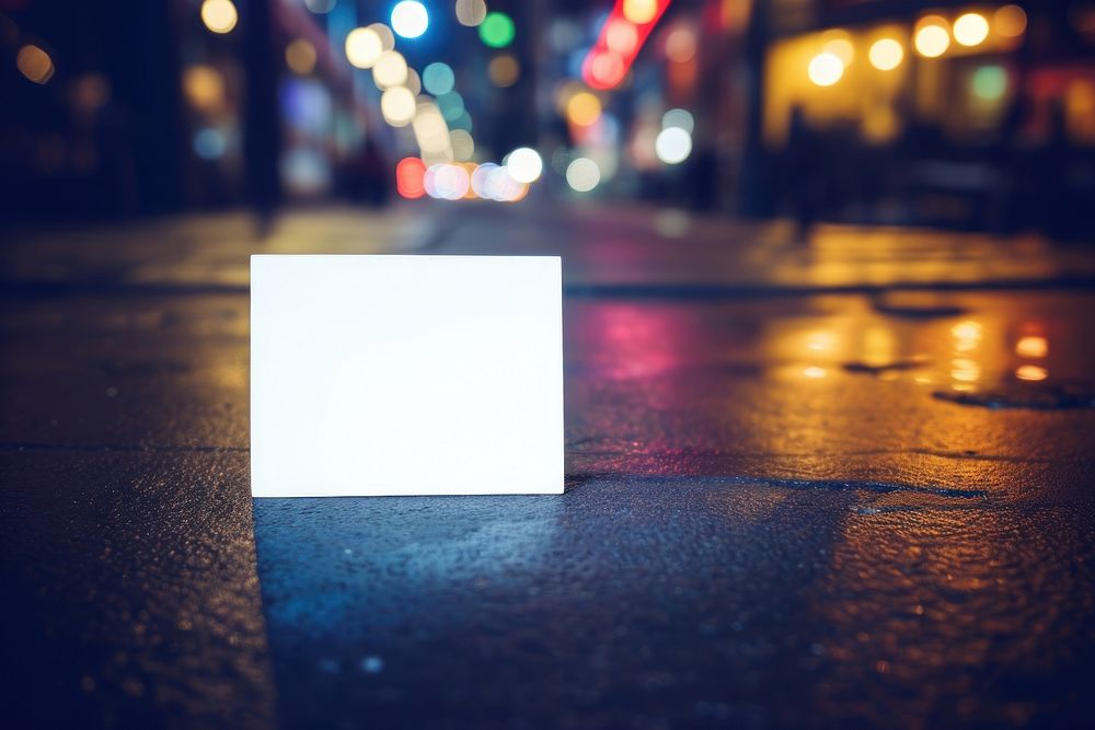 A white business card on the floor street night outdoors lighting.